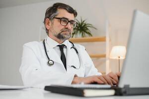 Portrait of senior doctor sitting in medical office. photo