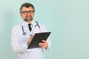 sonriente médico mayor médico con un estetoscopio. en un azul antecedentes. el concepto de de la humanidad victoria terminado enfermedad foto