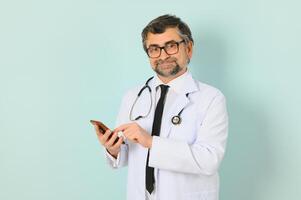 mayor médico hombre vistiendo estetoscopio y médico Saco terminado azul antecedentes. alegre expresión foto