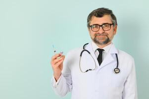 masculino médico participación jeringuilla, aislado azul antecedentes foto