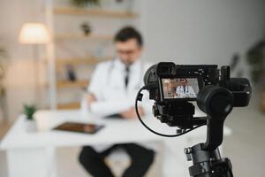 Handsome male doctor recording for medical blog photo