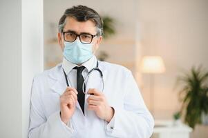 retrato de cuidado de la salud obrero. imagen de mayor masculino médico vistiendo laboratorio Saco y en pie a privado clínica foto