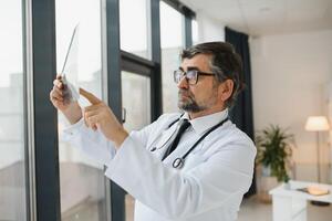 más viejo hombre médico examina radiografía imagen de livianos en un clínica foto