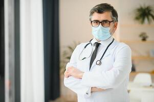 retrato de cuidado de la salud obrero. imagen de mayor masculino médico vistiendo laboratorio Saco y en pie a privado clínica foto