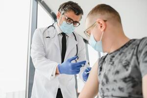 Man with face mask getting vaccinated, coronavirus, covid-19 and vaccination concept photo