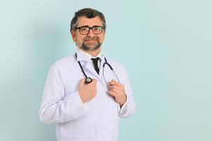 sonriente médico mayor médico con un estetoscopio. en un azul antecedentes. el concepto de de la humanidad victoria terminado enfermedad foto