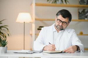 Portrait of attractive mature doctor working in office. photo