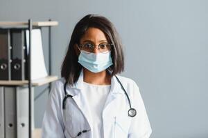 medicine, profession and healthcare concept - close up of african female doctor or scientist in protective facial mask photo