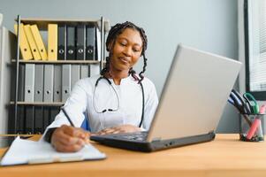 African female doctor make online telemedicine call consult patient. Afro american black woman therapist talking to camera in remote conference chat. Webcam view, face headshot. photo