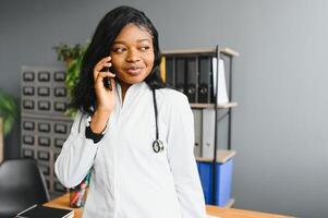 Smiling female doctor using mobile phone in the hospital. photo