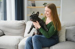 joven mujer con su perro a hogar. encantador mascota foto