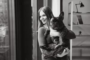 Female owner playing with joyful dog at home. Playing with dog concept photo