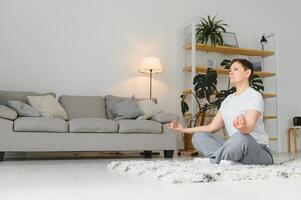 Middle-aged woman doing yoga at home for stretching and being healthy. photo