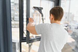 beautiful senior woman cleaning window glass. photo