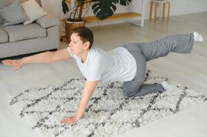 Adult woman doing fitness exercises at home. Senior woman do stretching exercises. Mature woman doing yoga poses photo