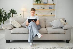 people, technology and internet concept - happy middle aged woman with tablet pc computer at home. photo