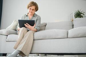 Smiling senior woman at home connected on internet photo