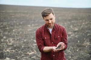 Farmer's hands hold a handful of fertile soil. The concept of agriculture, agribusiness. The gardener holds humus, fertilized soil, compost soil in his palms. Agriculture and fertility. photo