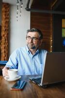 man using laptop in cafe bar photo