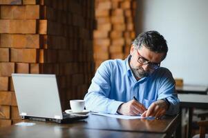 man using laptop in cafe bar photo