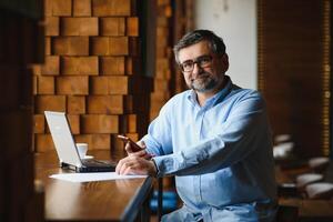 man using laptop in cafe bar photo