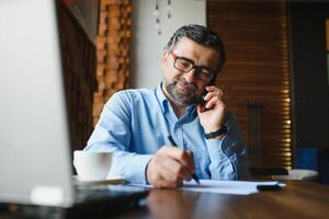 man using laptop in cafe bar photo