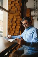 Newspaper in the morning. Senior businessman at his office riding newspapers. photo