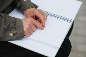 Old woman' s hands, reading a book with braille language. photo