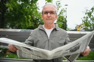 Old gray-haired man rest on the bench in summer park photo