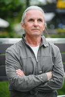 Old gray-haired man rest on the bench in summer park photo