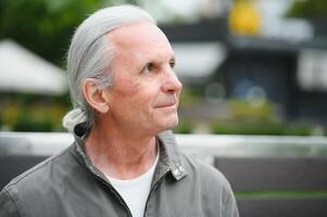 Old gray-haired man rest on the bench in summer park photo