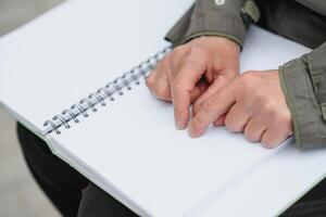 Blinded man reading by touching braille book photo