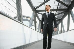 Stockbroker near the office. A successful and advanced handsome business man in a suit looks up in front of him standing on the background of concrete steps. photo