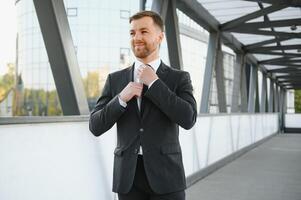 Stockbroker near the office. A successful and advanced handsome business man in a suit looks up in front of him standing on the background of concrete steps. photo