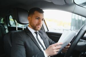 Attractive elegant happy man in good car photo