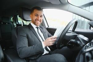 Attractive elegant happy man in good car photo