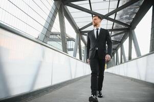 Stockbroker near the office. A successful and advanced handsome business man in a suit looks up in front of him standing on the background of concrete steps. photo