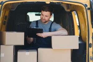 The courier brought the delivery of the box to the client. Courier service employee in uniform. photo