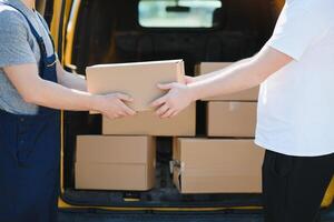 The courier brought the delivery of the box to the client. Courier service employee in uniform. photo