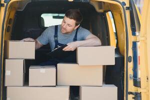 Delivery men unloading moving boxes from car photo