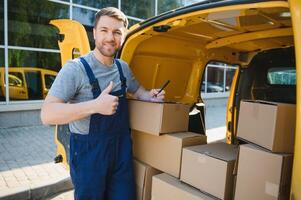 My deliveries are all running on schedule. Portrait of a delivery man unloading boxes from his van. photo