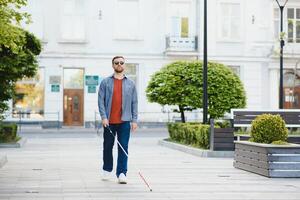 ciego hombre. personas con discapacidad, minusválido persona y todos los días vida. visualmente dañado hombre con caminando palo. foto