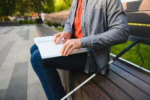 Blinded man reading by touching braille book photo