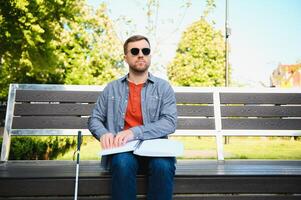 blind man sitting on a bench photo