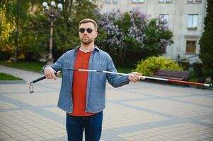 Close-up Of A Blind Man Standing With White Stick On Street photo