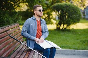 Blinded man reading by touching braille book photo