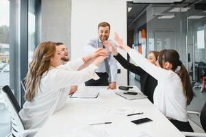 un grupo de negocio personas socios durante un conjunto equipo reunión en el moderno oficina. trabajo en equipo concepto foto