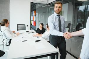 confidente y exitoso equipo. grupo de personas son trabajando juntos en oficina. borroso antecedentes foto