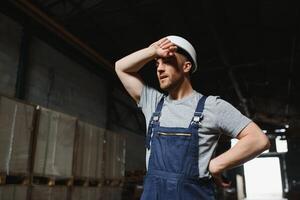 Portrait of happy male worker in warehouse standing between shelves. photo