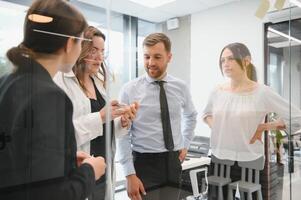 un grupo de negocio personas socios durante un conjunto equipo reunión en el moderno oficina. trabajo en equipo concepto foto